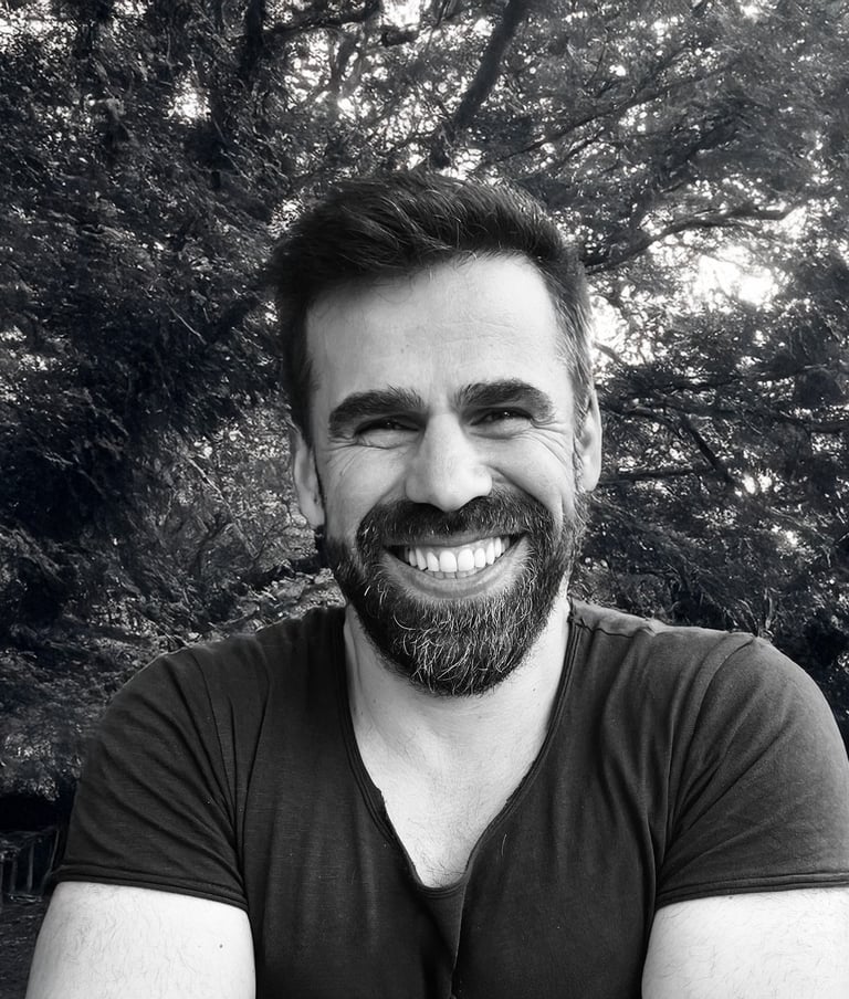 Adnan Erzen, Tai Ji and Qi Gong instructor at WDP Türkiye, smiling outdoors in a forest setting.