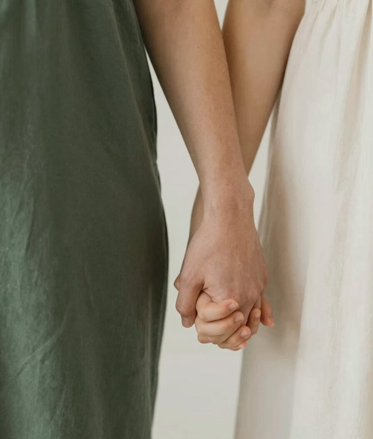 Close-up of parents holding a toddler's hand. Serene and heartfelt elegance, modern minimalism. Warm intimate storytelling. Earthy tones highlighting dark green (#2A362B), muted green (#5F705B), warm beige (#C7B7A3), and off-white (#F7F3EE).