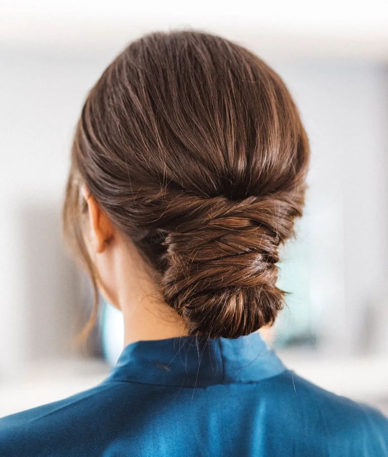 A bride wearing her hair in a low effortless bun with twists