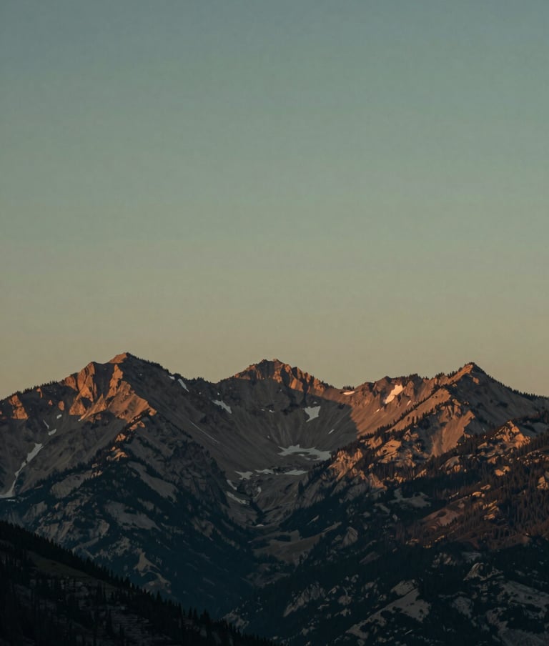 A stunning, atmospheric outdoor photography shot of a North American / US mountain range at dusk. The sky is a muted charcoal and sage green, conveying a thought-provoking and calm mood. High-resolution cinematic quality.