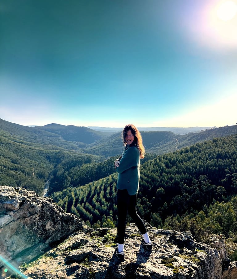 Woman smiling on mountain cliff with valley view, yoga and psychology counseling