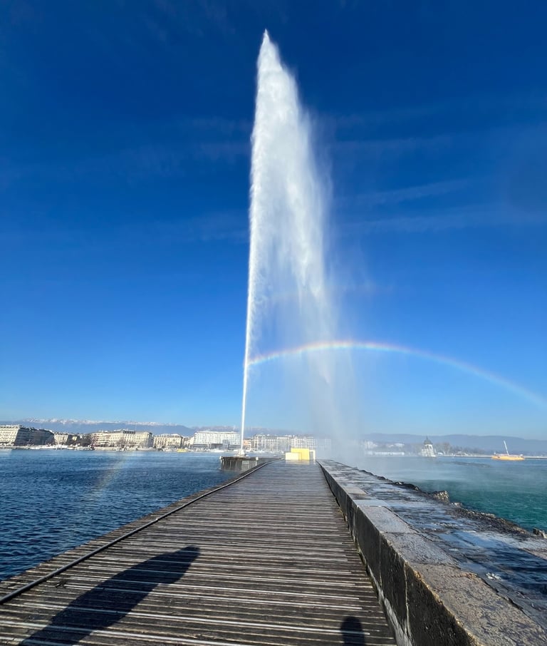 View of the Jet d'Eau forming a rainbow over a pier in Geneva, Switzerland