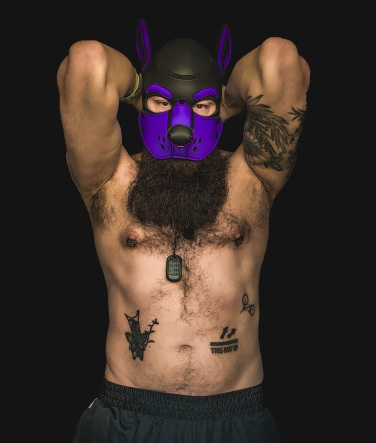 Man in a pup mask flexing bare chested