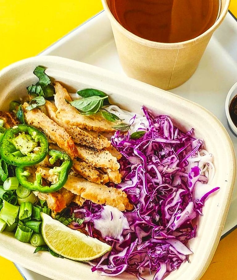 A savory plant-based patty adds a bold twist to traditional pho, nestled among rice noodles,
