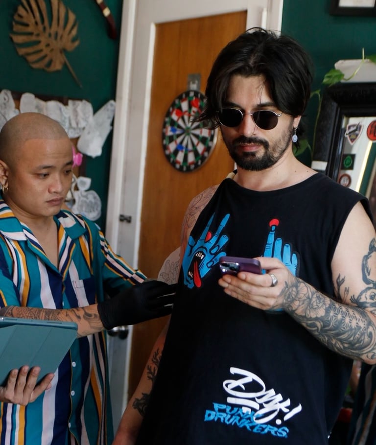 The tattoo artist is measuring the tattoo during the tattooing process for the customer.