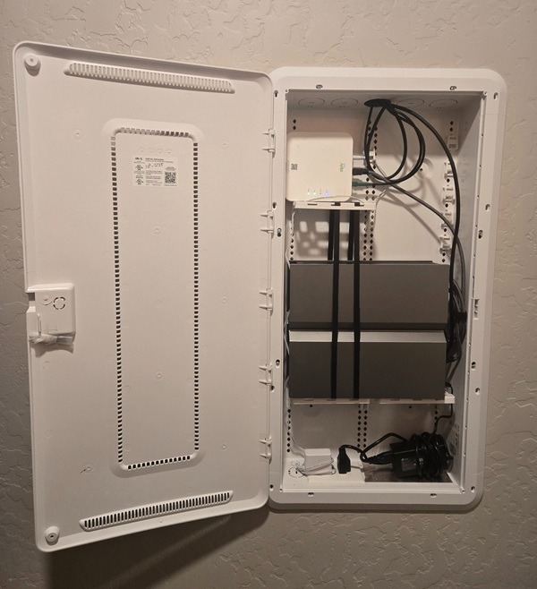 White recessed structured media enclosure with organized home networking equipment and cables.