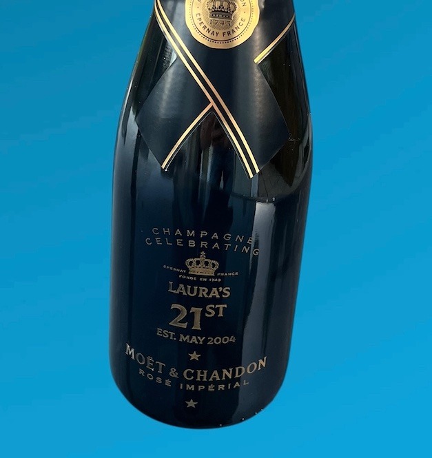 a bottle of champagne with bespok engraving for 21st