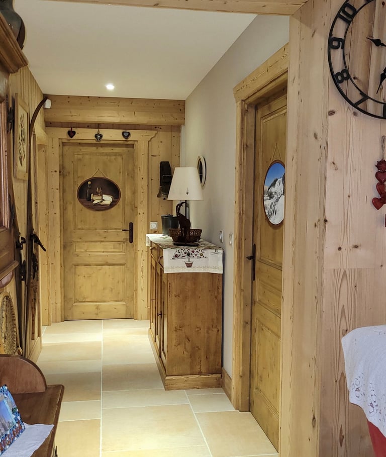 Intérieur d'un chalet dont les portes sont décorées de médaillons en trompe-l'oeil, thème jurassien.