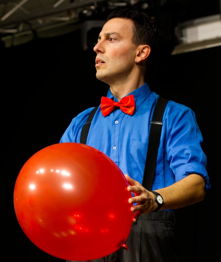 Pascal the clown in scena con un palloncino rosso fiammante come il suo papillon