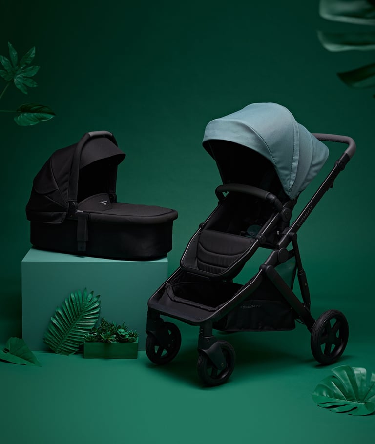 Product campaign photography - a baby stroller with a baby carriage in a green background