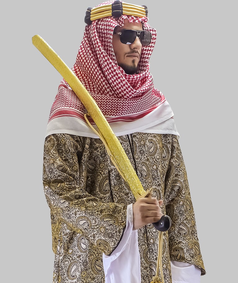 Saudi man in traditional thobe, bisht, and shemagh holding a golden prop sword.