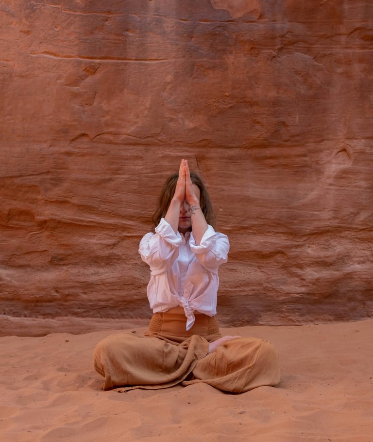 a woman in a white shirt and pants is doing yoga