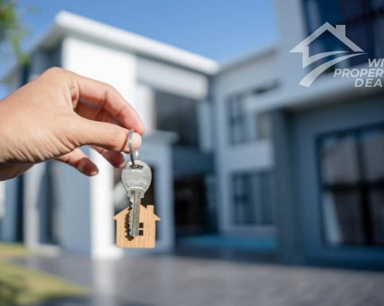 keys and a house in background
