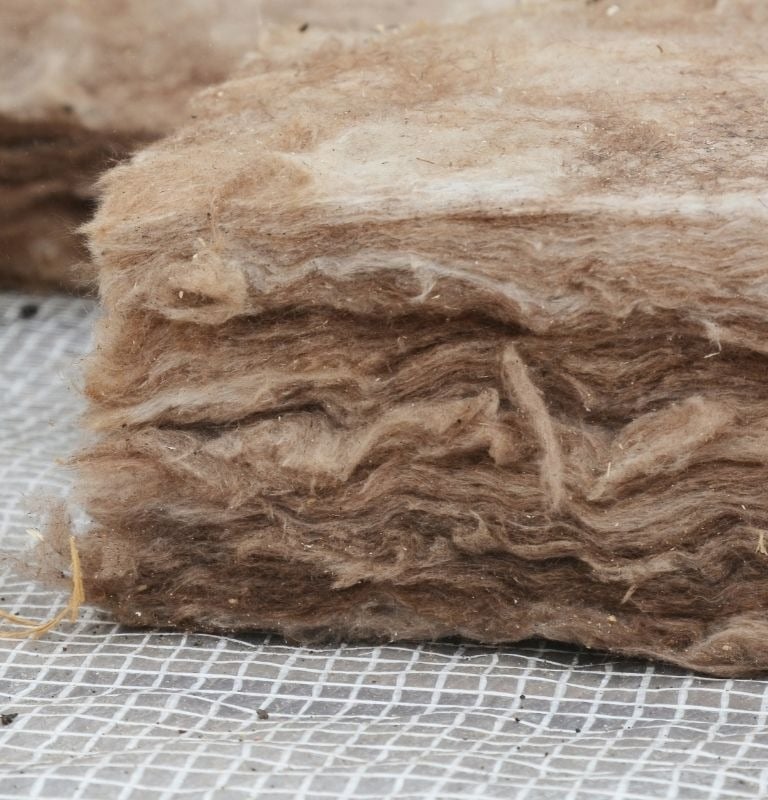 Gros plan sur un isolant écologique en laine de bois installé sous une toiture à Belfort, pour une solution naturelle et perf