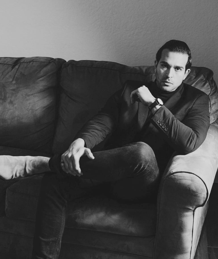 a well dressed man who knows how to plan an excellent date sitting on a sofa 