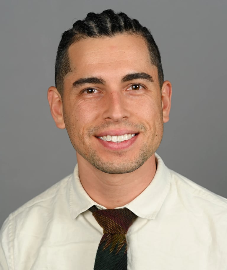 Daniel Alvarez in a cream shirt and tie