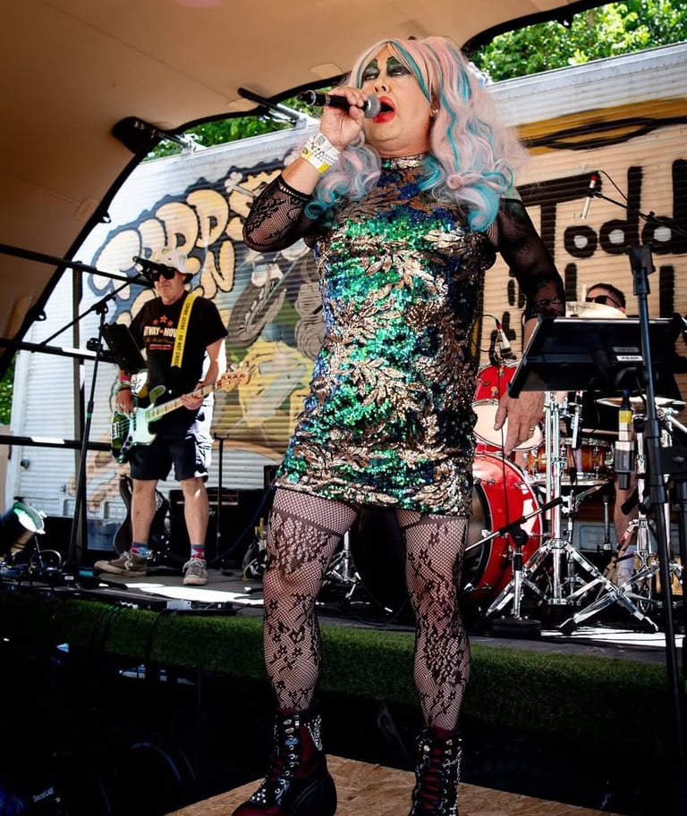 Magenta slipperz comedy drag ace singing at a festival