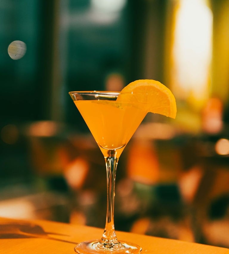 a cocktail in a martini glass with a slice of lemonade