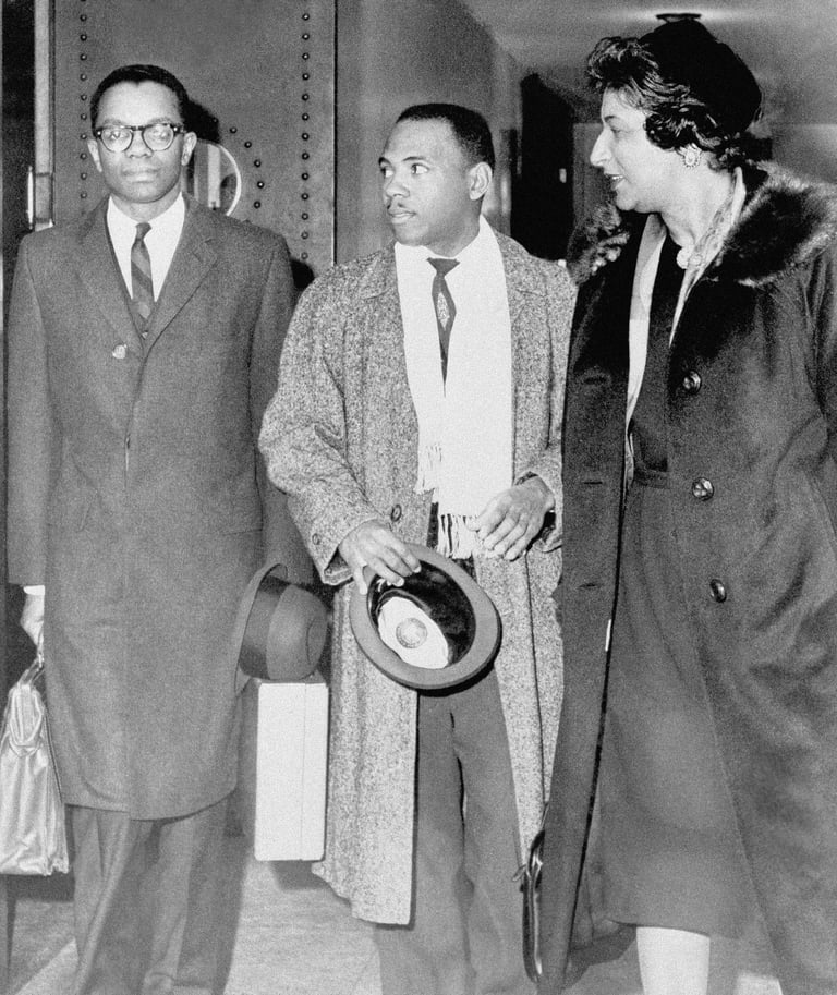 two men in a suit and tie standing next to a woman in a suit