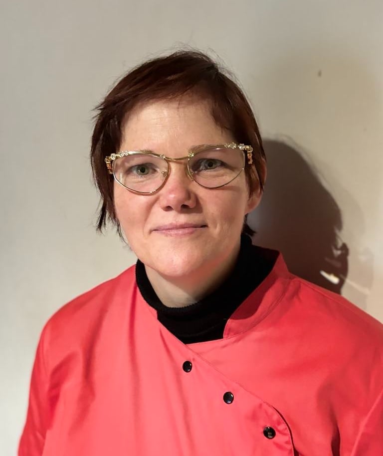 a nurse in a pink jacket and glasses