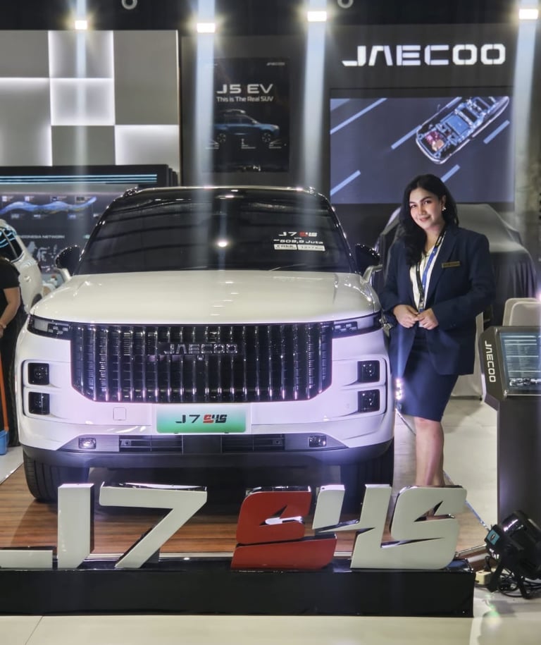 Tisna Sales Executive Standing With Jaecoo Car In Showroom. Jaecoo Makassar