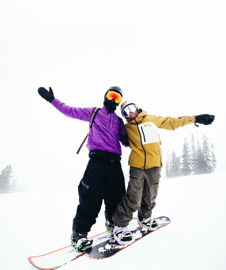 Happy snowboarders on mountain representing successful coaching by GJ Silver