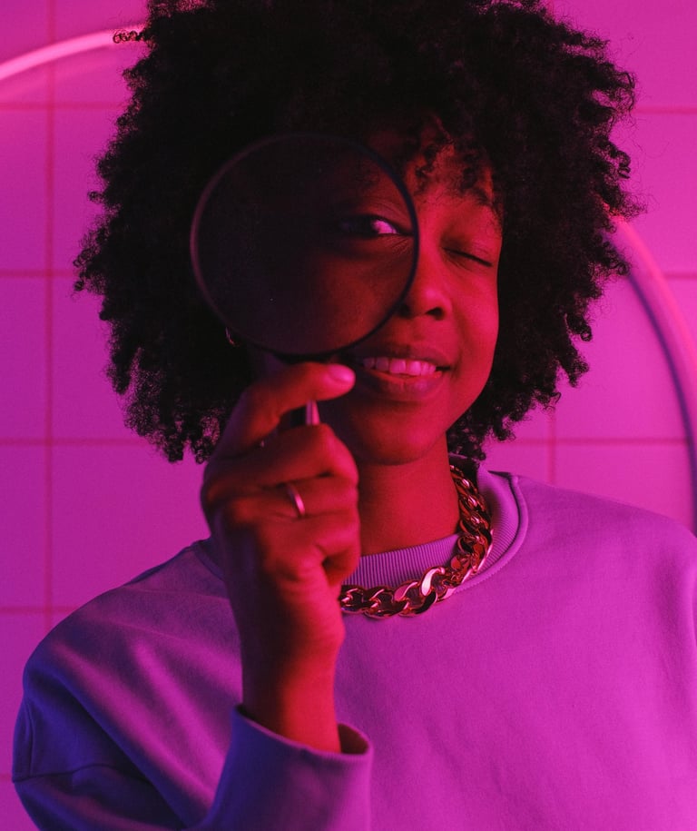 Una niña sostiene una lupa delante de su cara.