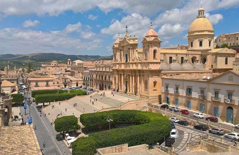 La cattedrale di Noto, la sua scalinata, il barocco ed un cielo azzurro.