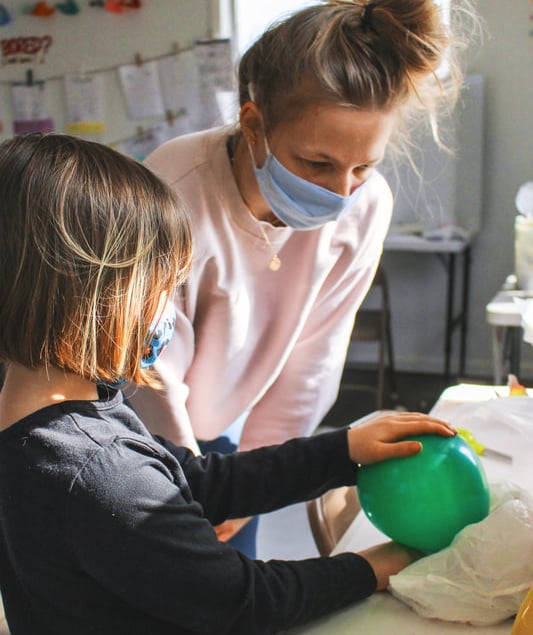 Young teen helping a youth student with her project.