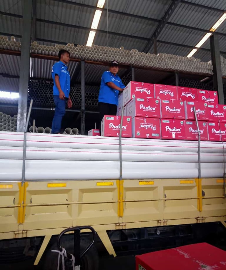 two men standing on a truck with boxes fittings pralon knee pipa pvc 
