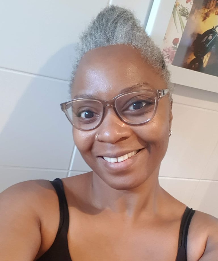 a Black woman with glasses and a black top