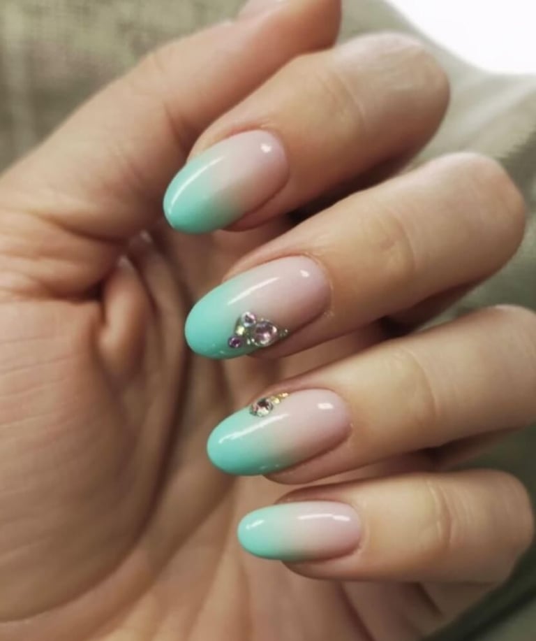 Sage green nails with neutral base and black leaf outlines finished with glitter tips – botanical in