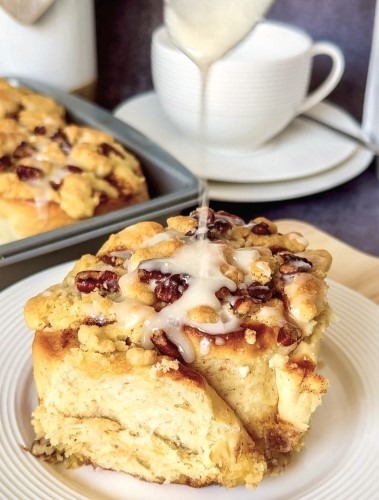 single apple-cinnamon roll with streusel-nut topping just getting the icing drizzle - (c) BREADISTA and Chew on This