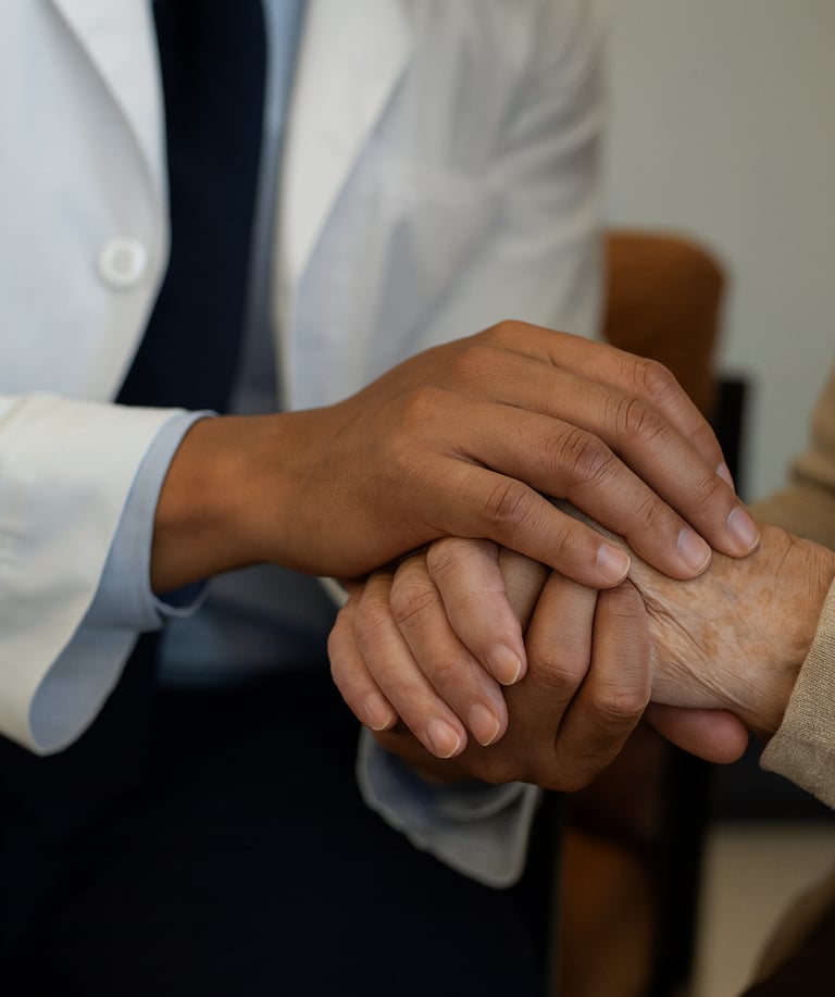 Neurology provider offering supportive care, holding a patient’s hand during consultation.
