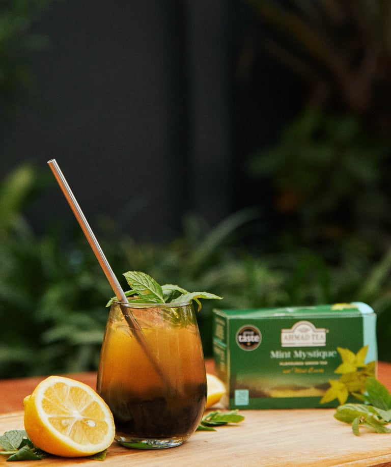 a glass of iced tea with a lemonade and mint leaves