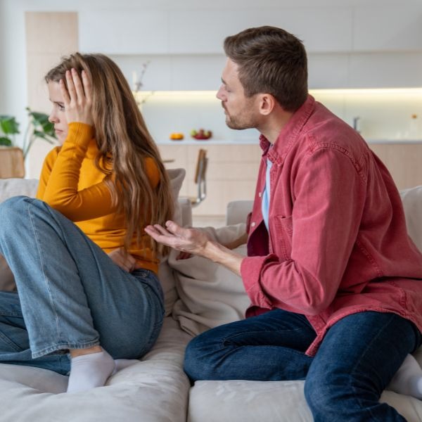 a man and woman sitting on a couch in a living room