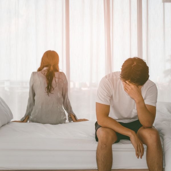 a man and woman sitting on a bed