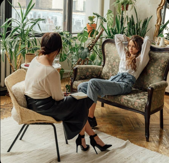 a woman sitting on a chair in a room with a therapist