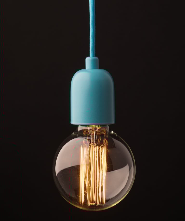 Product photography - a light bulb hanging on a black background