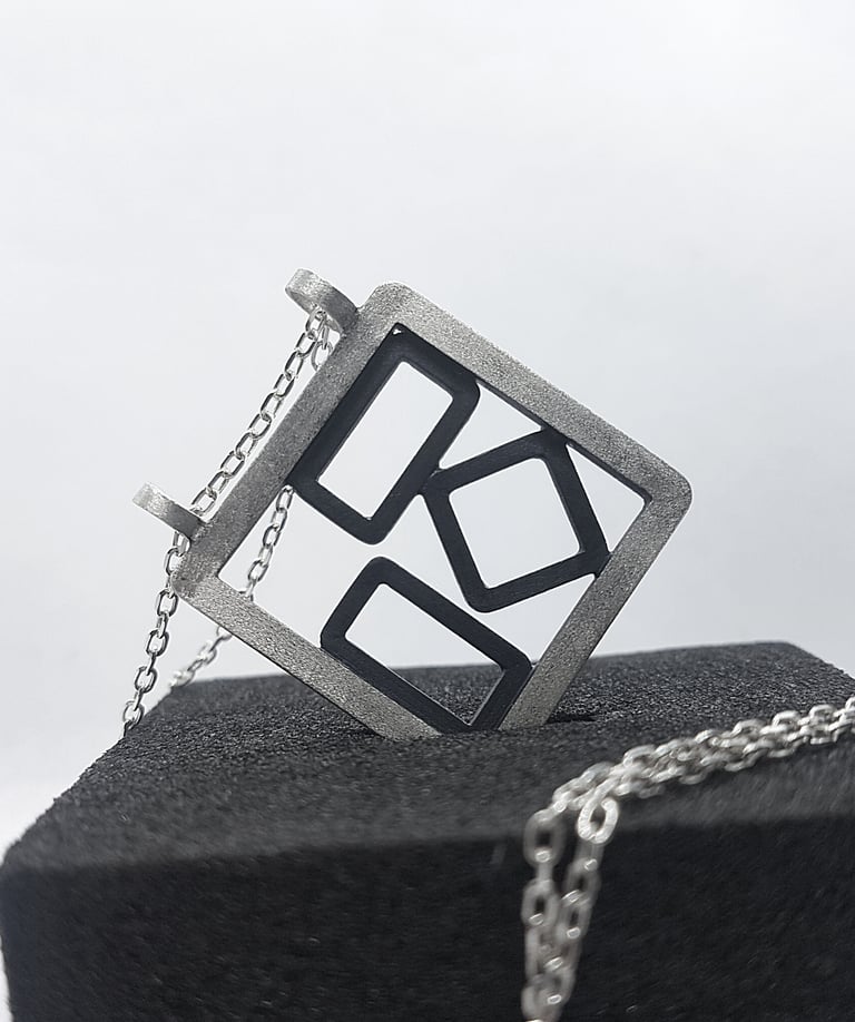 a square shaped pendant with a geometric design