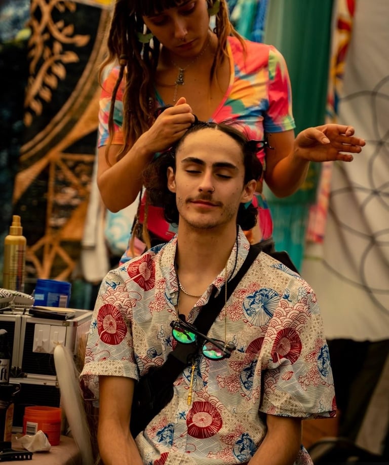 a woman braiding a mans hair at a festival