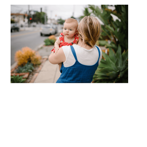 Mother walking down the street carrying baby