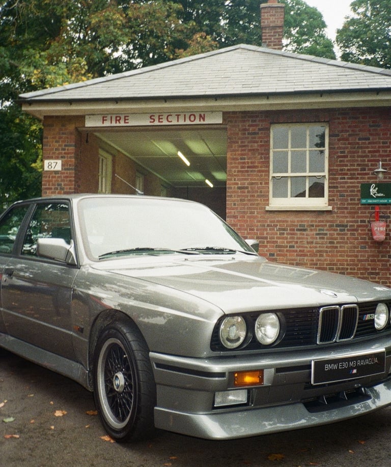 a classic BMW parked in front of a brick building