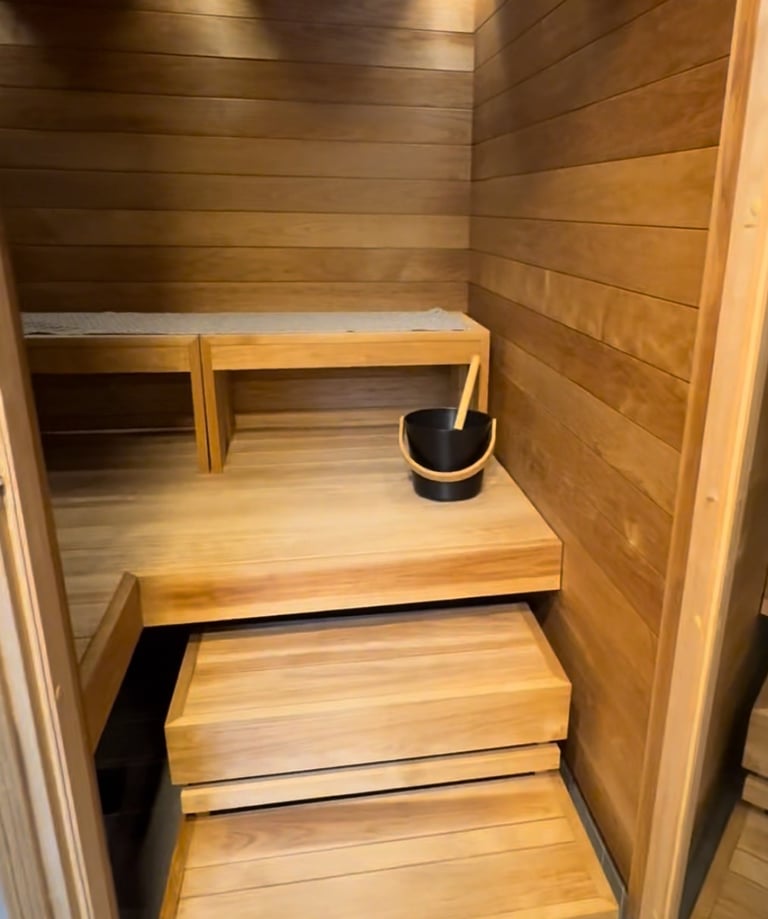 a wooden sauna with black water bucket