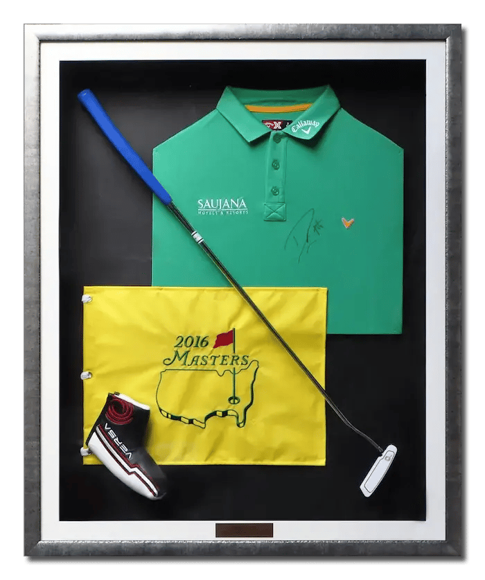 Golf memorabilia - club, flag and shirt framed in a dark silver shadow box frame