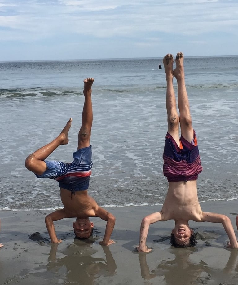 4 boys doing headstands on the beach in Rye, New Hamsphire