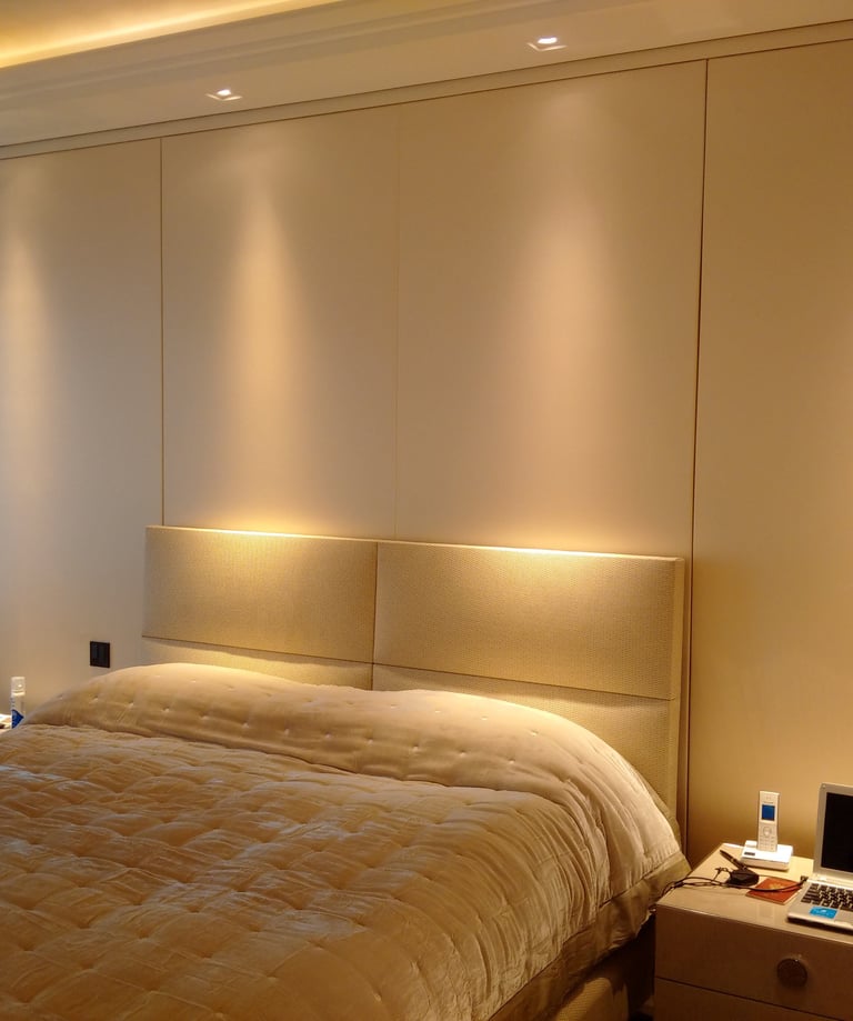 Soft fabric wall finish used behind a bedroom headboard.