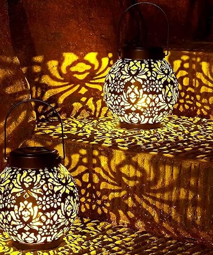 two lanterns with intricate designs on them on a staircase case