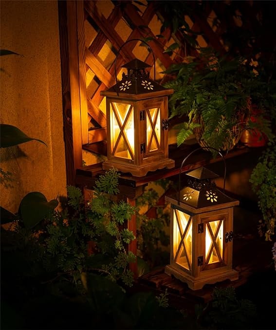 two lanterns with lights on a wooden table