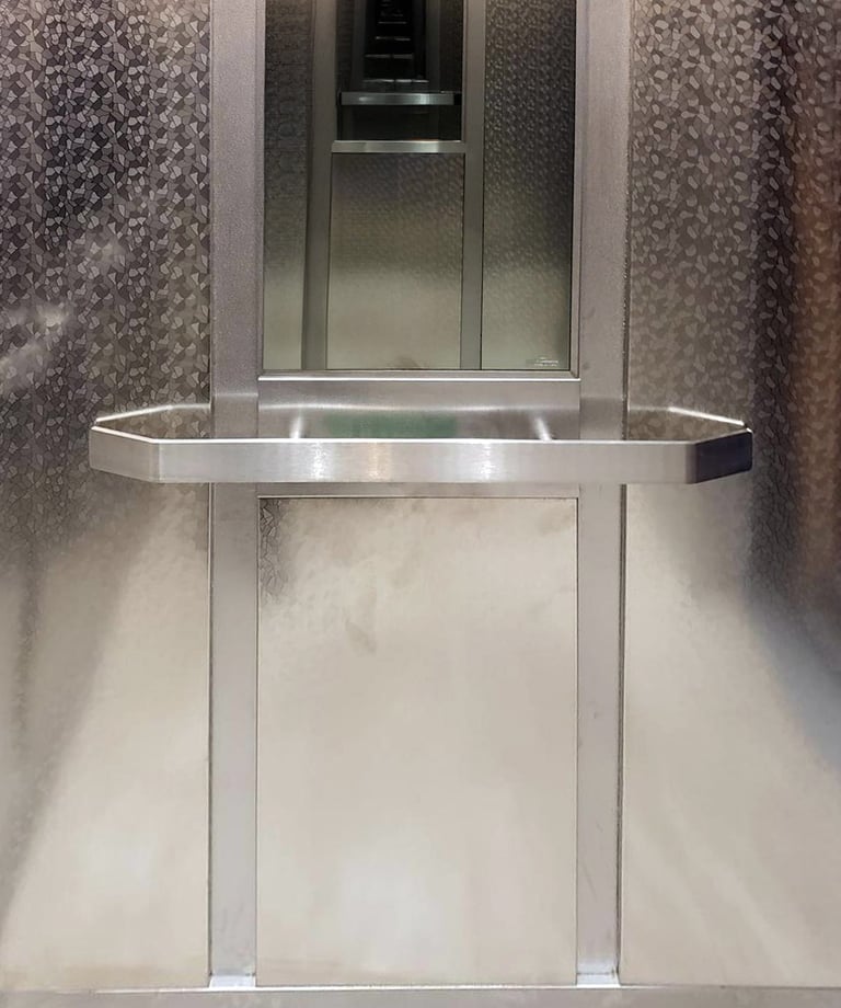 elegent elevator interior with embossed steel, flat handrails and a mirror